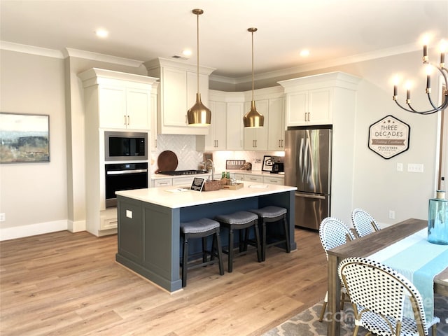 kitchen featuring light wood-style floors, white cabinets, appliances with stainless steel finishes, ornamental molding, and tasteful backsplash