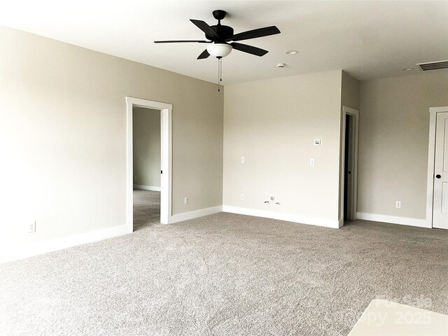 carpeted spare room with baseboards, visible vents, and ceiling fan