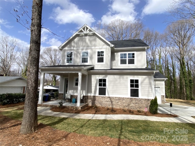 view of front of property featuring brick siding, board and batten siding, a porch, and a shingled roof