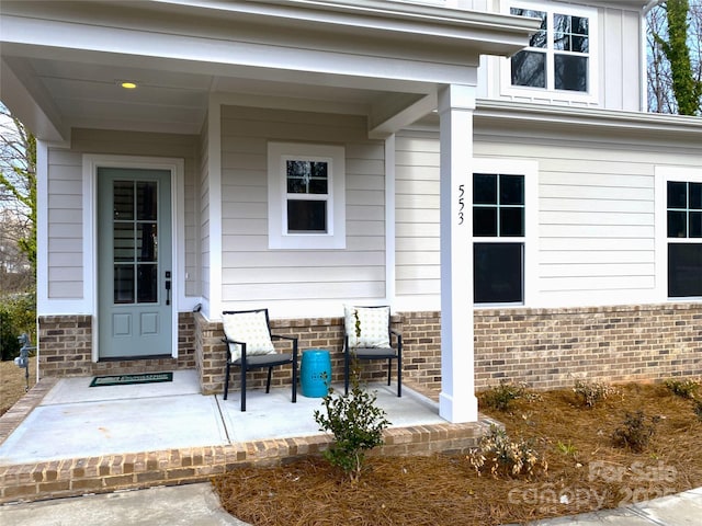 property entrance with brick siding and board and batten siding