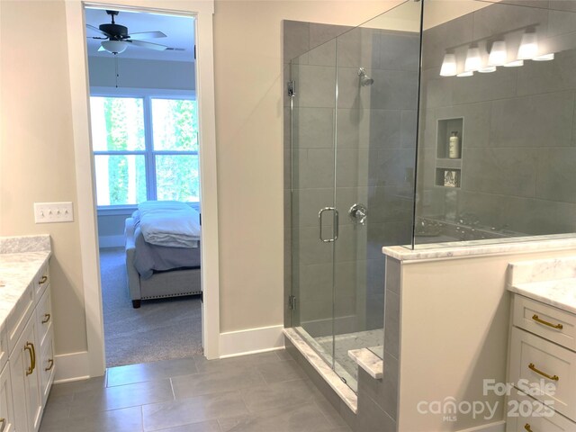 ensuite bathroom featuring a stall shower, connected bathroom, ceiling fan, tile patterned flooring, and vanity