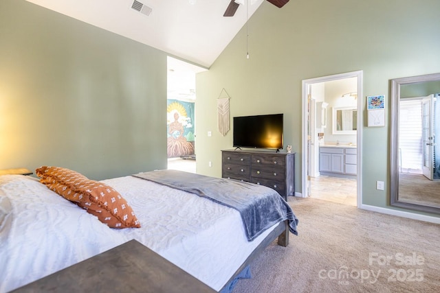 bedroom featuring high vaulted ceiling, sink, light colored carpet, ceiling fan, and ensuite bath