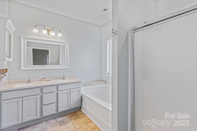 bathroom with vanity, a bath, and tile patterned floors