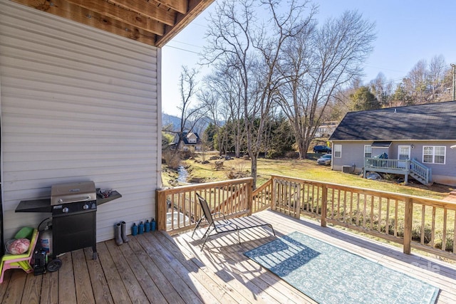 wooden terrace with a yard and grilling area