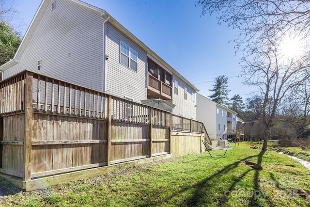 back of house with a wooden deck and a lawn