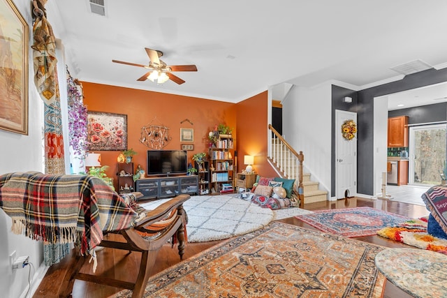 living room featuring ornamental molding, wood-type flooring, and ceiling fan