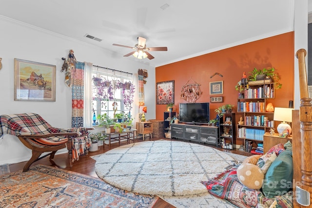 living room featuring hardwood / wood-style floors, ornamental molding, and ceiling fan