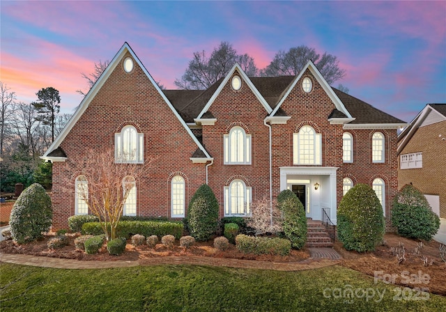 view of front of home with a front yard and brick siding