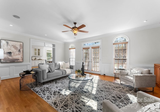 living room featuring light wood finished floors and crown molding