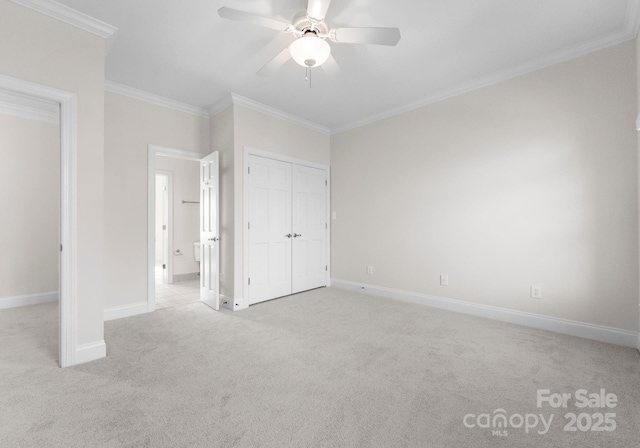 unfurnished bedroom featuring ornamental molding, a closet, light colored carpet, and baseboards