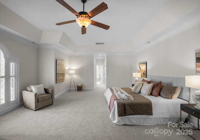 bedroom with a raised ceiling, light colored carpet, visible vents, ornamental molding, and baseboards