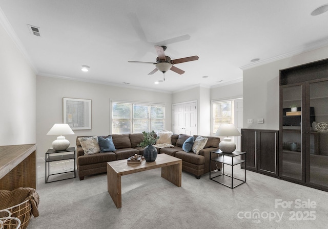 living area with ornamental molding, a healthy amount of sunlight, and light colored carpet