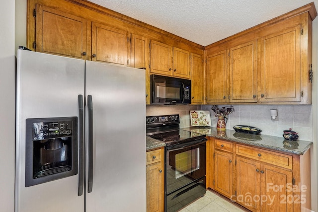 406 Brief Rd W, Indian Trail, NC 28079 - kitchen with dark stone counters, tasteful backsplash, a textured ceiling, black appliances, and brown cabinets