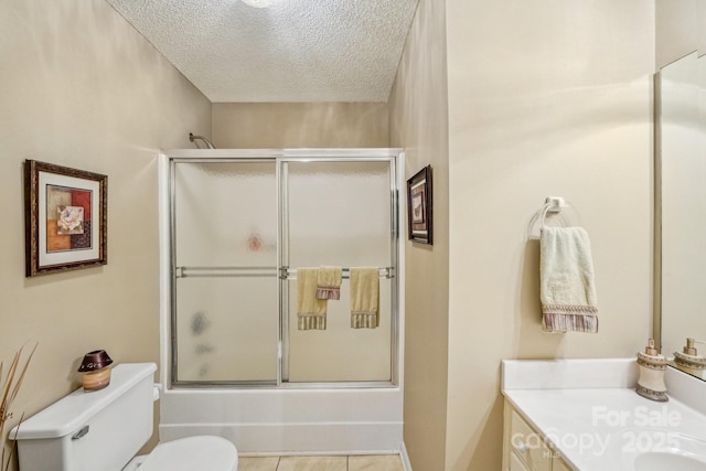 406 Brief Rd W, Indian Trail, NC 28079 - bathroom featuring a textured ceiling, vanity, bath / shower combo with glass door, toilet, and tile patterned flooring