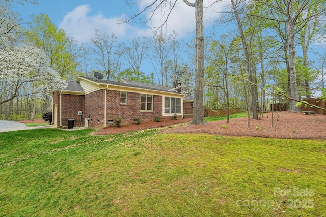 406 Brief Rd W, Indian Trail, NC 28079 - exterior space with driveway, a chimney, fence, brick siding, and a lawn