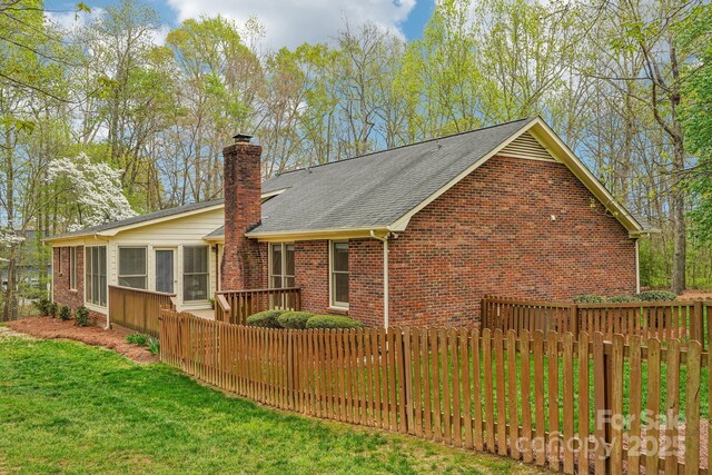 406 Brief Rd W, Indian Trail, NC 28079 - exterior space with brick siding, roof with shingles, a chimney, and fence