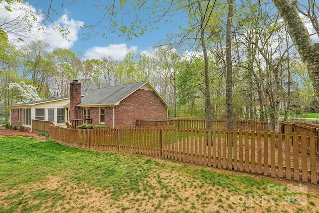 406 Brief Rd W, Indian Trail, NC 28079 - view of home's exterior featuring a chimney, a yard, brick siding, and a fenced backyard