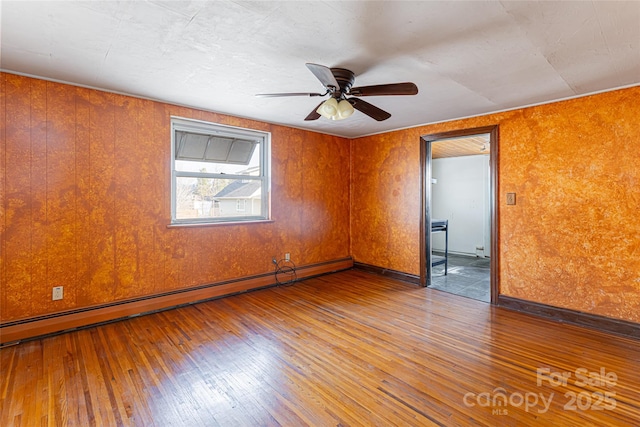 spare room featuring ceiling fan, a baseboard radiator, and hardwood / wood-style floors