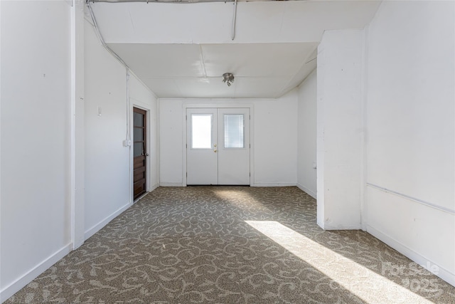 carpeted spare room featuring french doors