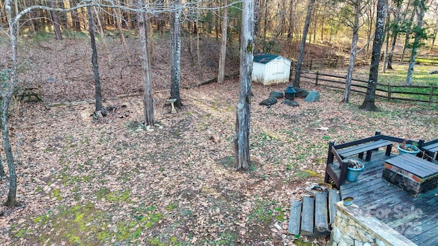 view of yard with a deck and a storage unit