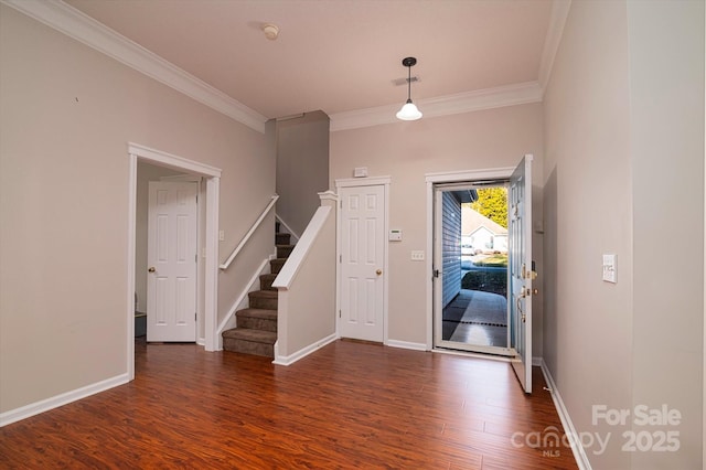 foyer entrance with crown molding and dark hardwood / wood-style floors