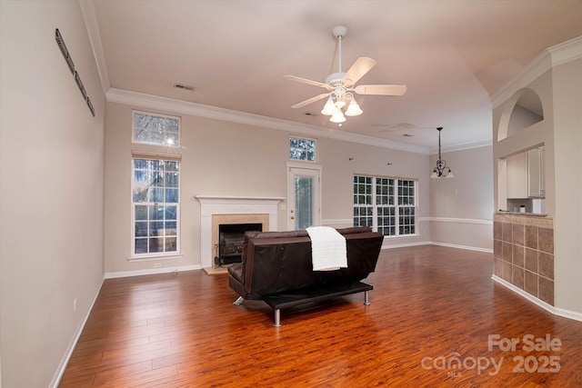 living room featuring ornamental molding, dark wood-type flooring, and ceiling fan