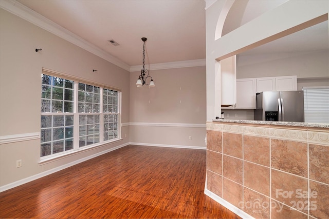 interior space featuring stainless steel fridge, ornamental molding, white cabinets, dark hardwood / wood-style flooring, and a chandelier