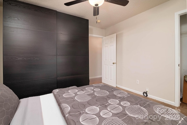 unfurnished bedroom with ceiling fan and a textured ceiling