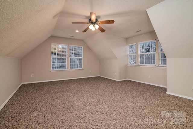 bonus room with carpet floors, vaulted ceiling, a textured ceiling, and plenty of natural light