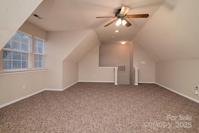 bonus room featuring ceiling fan, lofted ceiling, carpet, and a textured ceiling