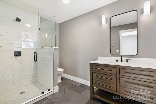 bathroom with vanity, a shower with shower door, and toilet