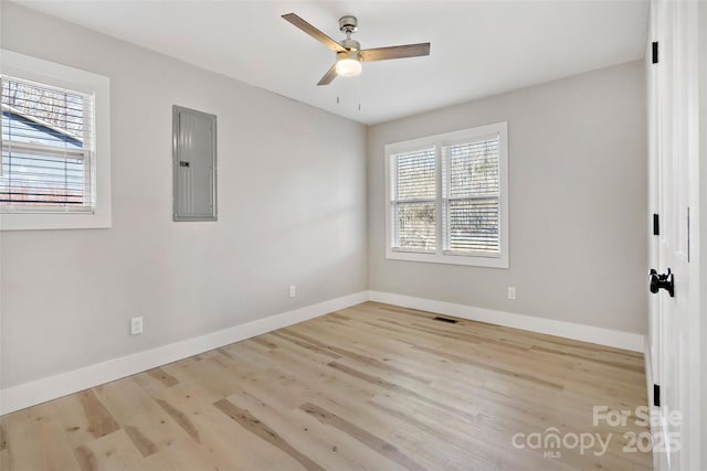 spare room featuring ceiling fan, electric panel, and light hardwood / wood-style floors