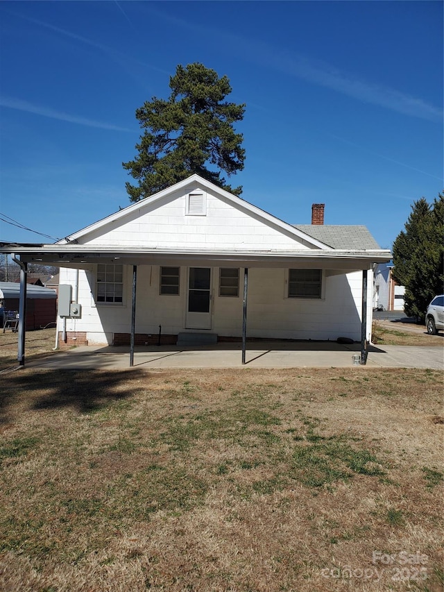 back of property featuring a yard