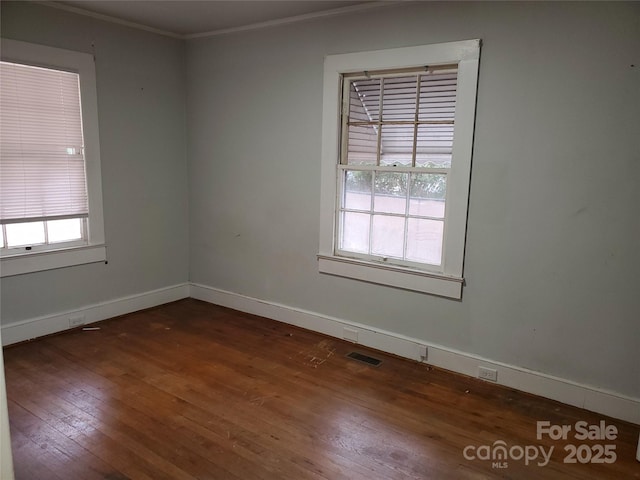 unfurnished room featuring crown molding and dark wood-type flooring