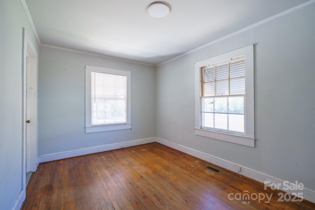 unfurnished room featuring wood-type flooring and ornamental molding