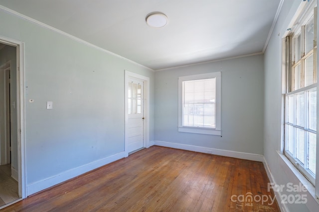 empty room with ornamental molding and hardwood / wood-style floors