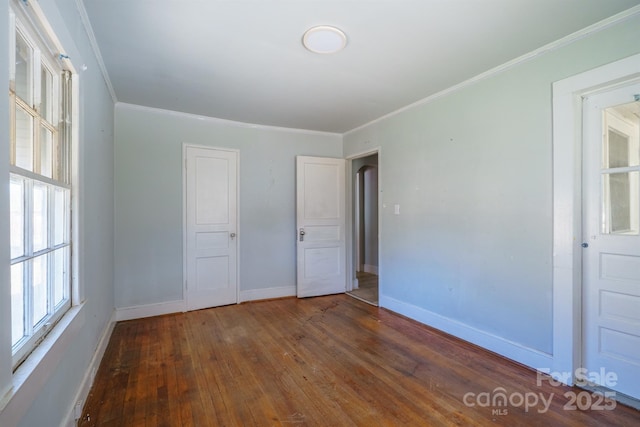 unfurnished bedroom with ornamental molding and dark hardwood / wood-style floors