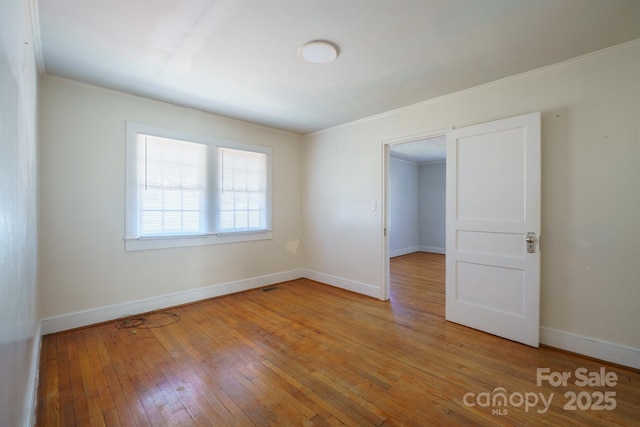 empty room featuring ornamental molding and light hardwood / wood-style floors