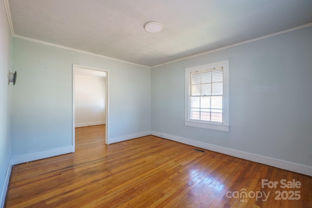 spare room featuring hardwood / wood-style flooring and crown molding