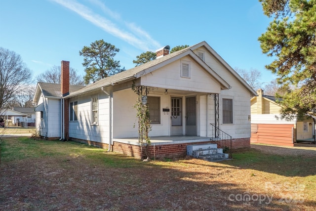 bungalow featuring a front lawn and a porch