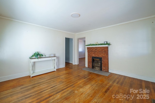 unfurnished living room featuring crown molding, a brick fireplace, and hardwood / wood-style flooring