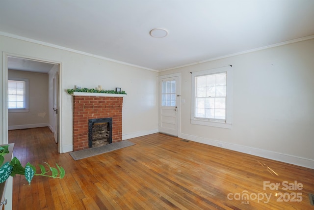 unfurnished living room with crown molding, a fireplace, and wood-type flooring