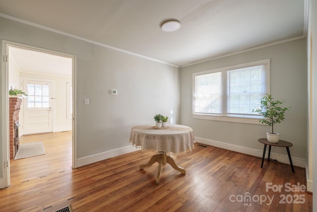 sitting room featuring wood-type flooring and ornamental molding