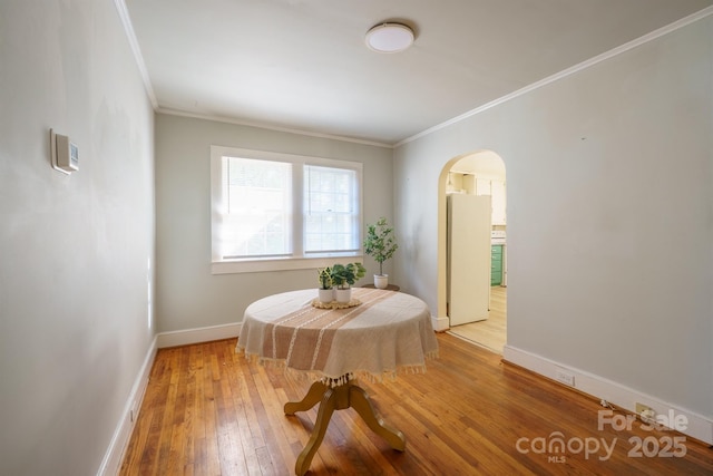 dining area with crown molding and wood-type flooring