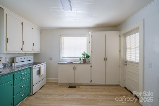 kitchen with white cabinetry, green cabinets, electric range, and light hardwood / wood-style flooring