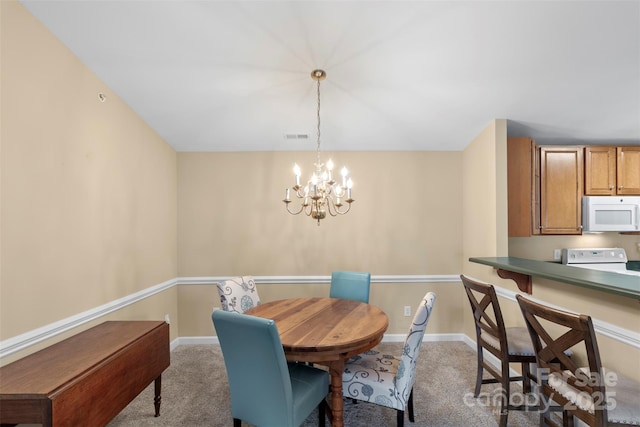 carpeted dining room with an inviting chandelier