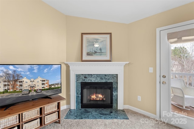 carpeted living room with a high end fireplace