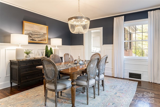 dining area featuring crown molding, a notable chandelier, and dark hardwood / wood-style flooring