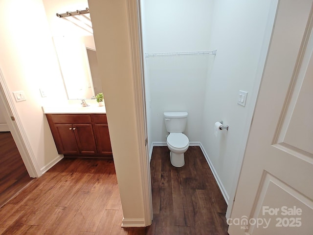 bathroom featuring vanity, toilet, and hardwood / wood-style floors