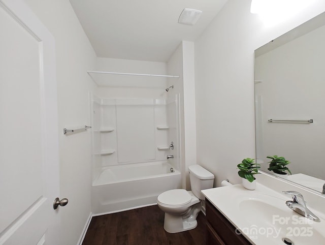 full bathroom featuring vanity, hardwood / wood-style floors, toilet, and washtub / shower combination